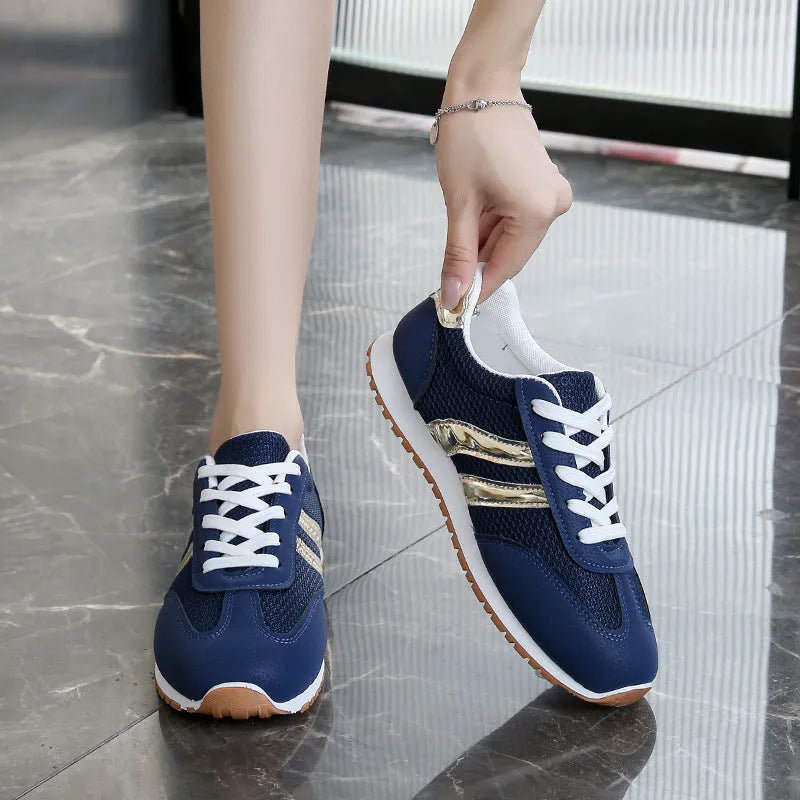 Blue women's artificial leather tennis shoes with cross shoulder straps and flat rubber sole.