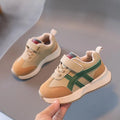Children's white synthetic leather sneaker with Velcro strap on a neutral background.