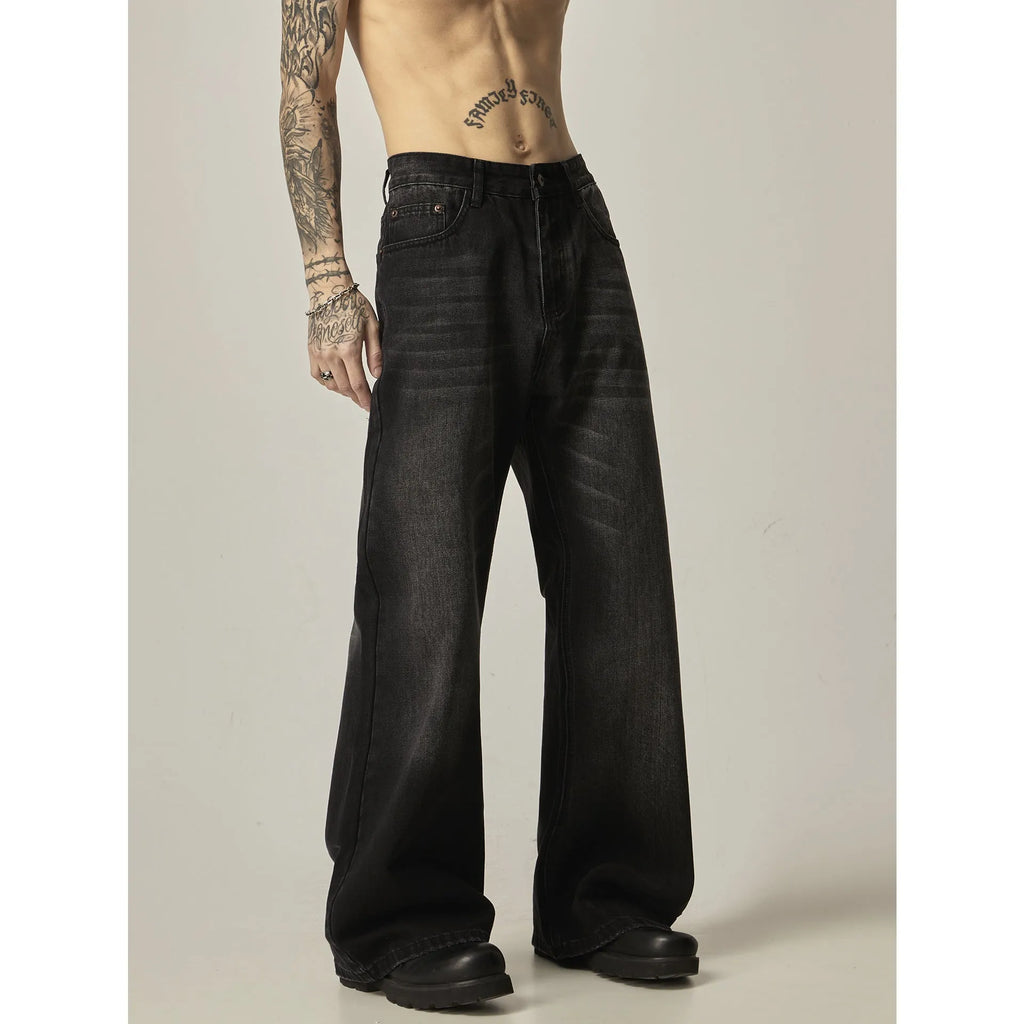 Black loose straight-leg retro jeans on a hanger, showing the front view with zipper fly.