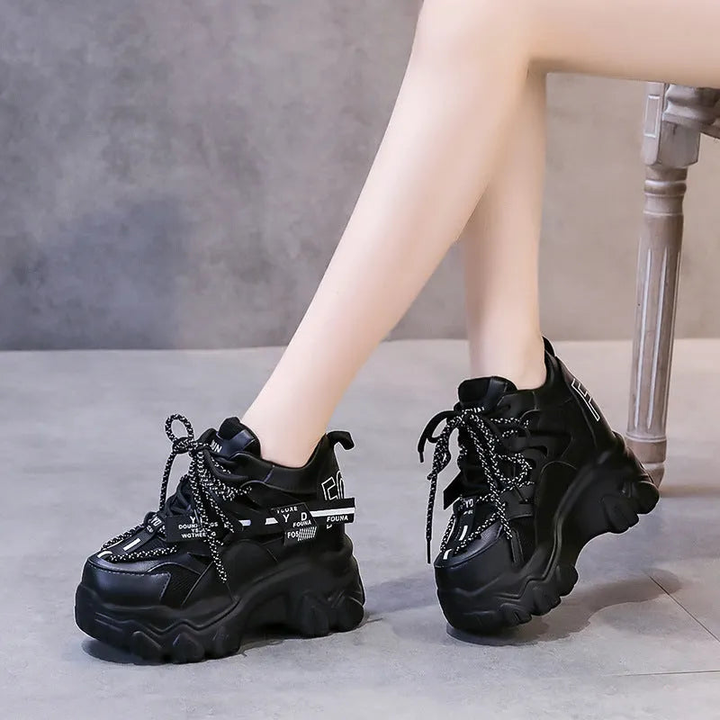 Women's white and black mesh platform tennis shoes with cross strap and thick rubber sole.