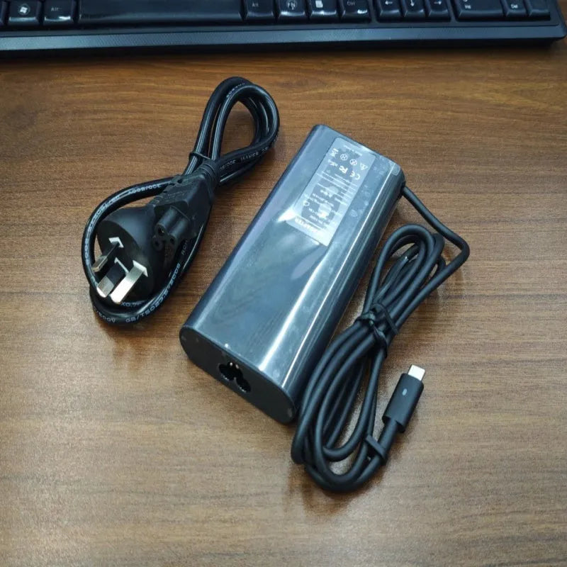 Black 65W USB-C laptop power adapter with six international travel plug cords.