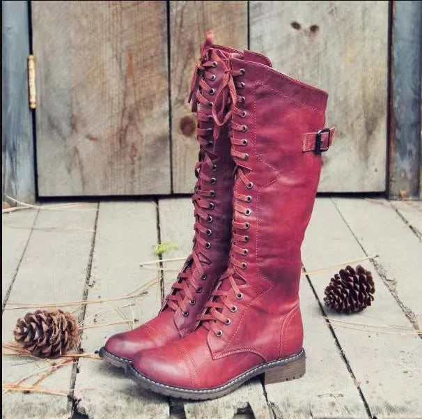 Women's black chunky heel high leg boots with a round toe on a plain background.