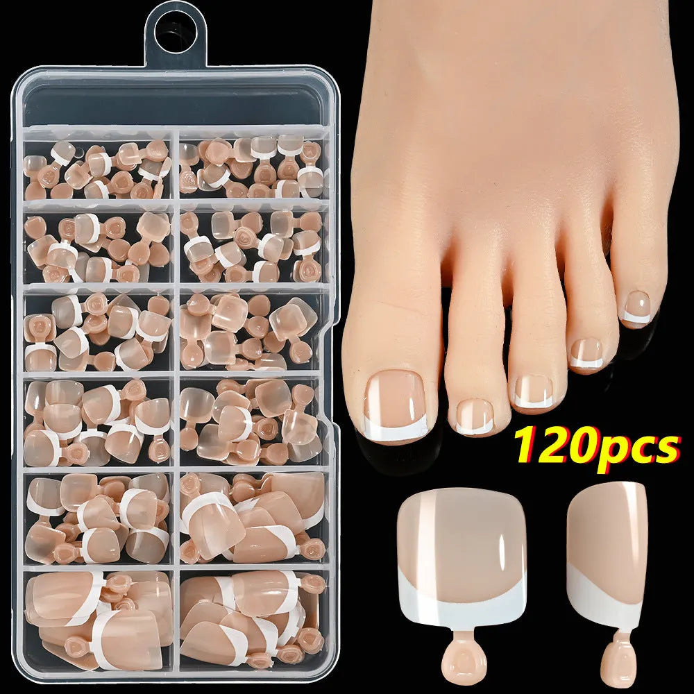 Box of 120 French white edge nude false toe nail pieces in assorted shades on a table