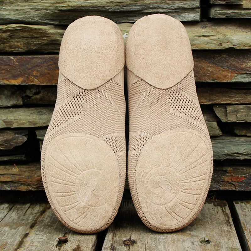 Camel colour dance yoga shoes with cotton mesh upper and leather sole on a plain background.