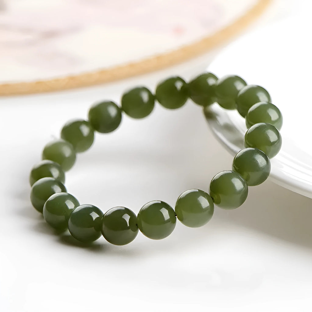 Polished Hetian jade ball bracelet on a wrist, showing ice-like clear beads in one of four available sizes.