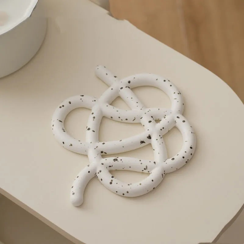 Ceramic heat proof mat with irregular shape and bend and hook design