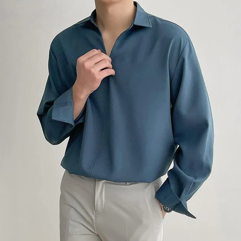 Man wearing a loose fit, solid colour, long sleeve casual shirt suitable for business.