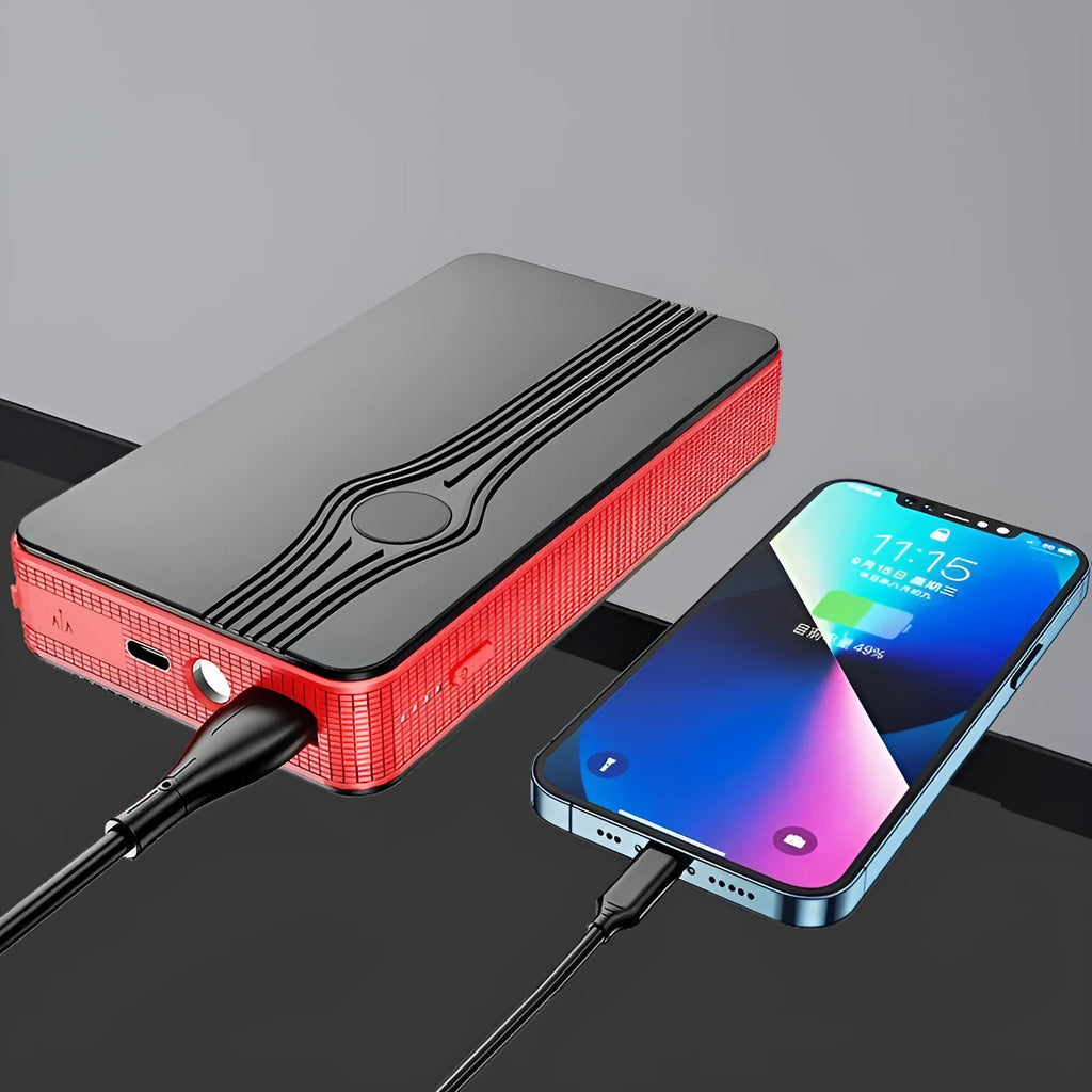 Red K4-E automobile emergency starting power supply and USB power bank unit on a grey surface.