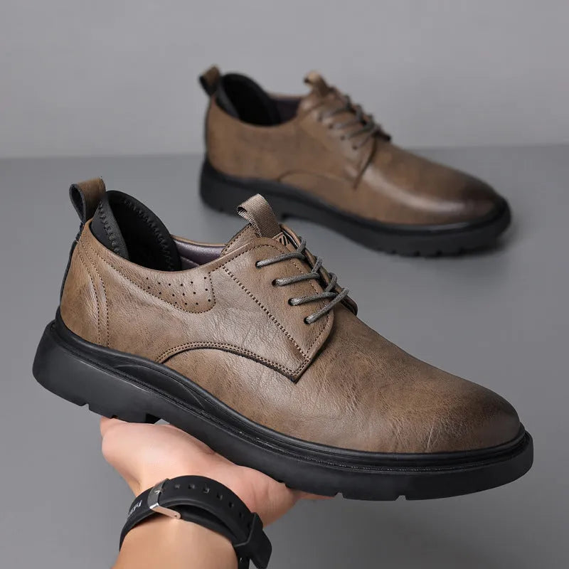 Men's black and brown leather casual sneakers with rubber sole and sewing line detail on the upper.