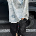 Korean style loose fit T-shirt with a full printed tie dye and dirty painting design on a solid colour background.
