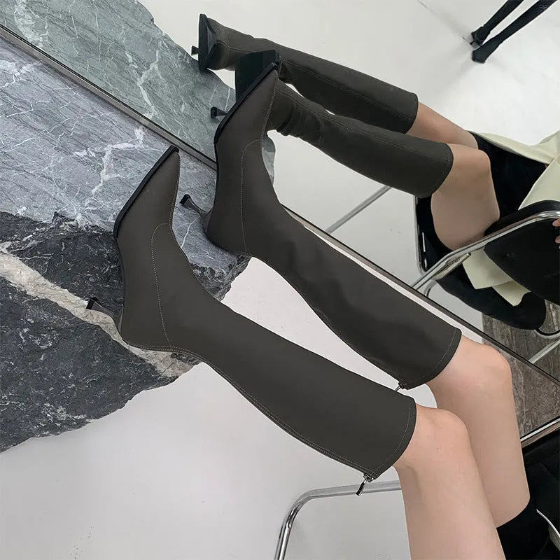 Black pointed toe below the knee stiletto heel boots with a back zipper fastening.