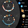 Set of twelve natural stone beaded bracelets laid out, each with a different design representing a zodiac sign.
