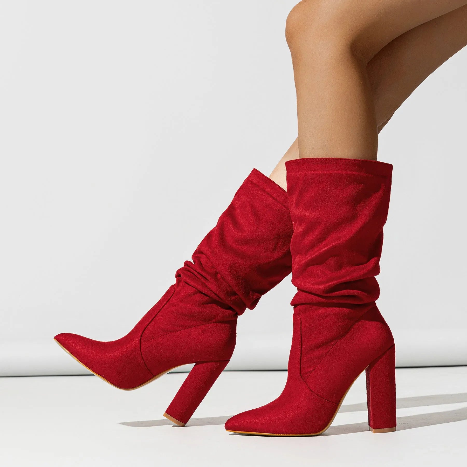 Women's black suede ankle boots with a high chunky heel and pointed toe.