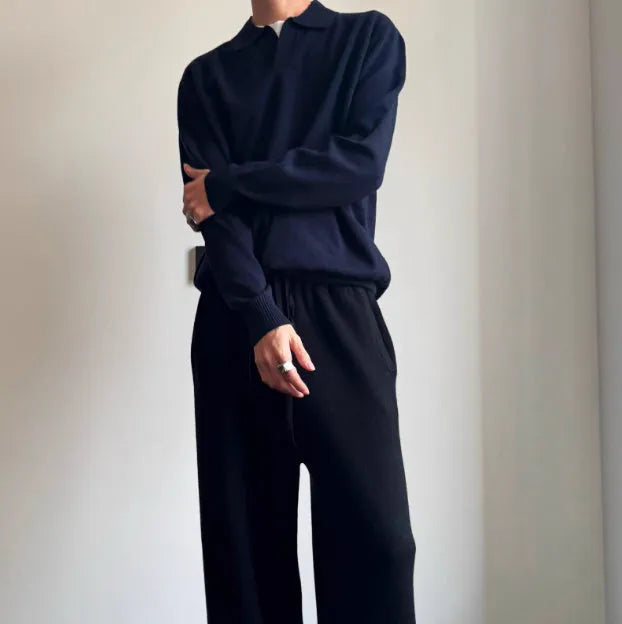 Man wearing a milky white pure wool polo sweater with a lapel collar and loose long sleeves.