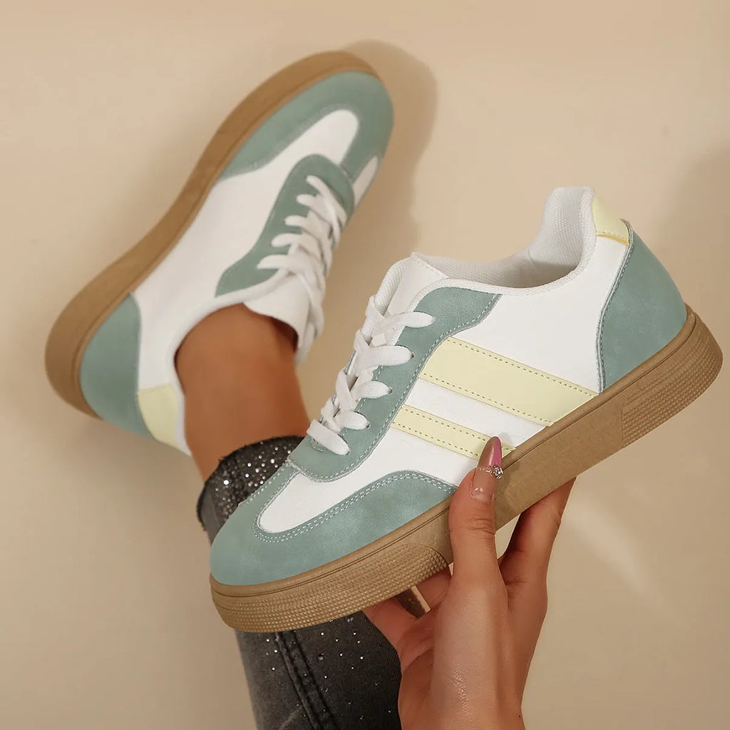 Women's retro sports shoes in white with green candy colour accents and cross-strap details on PU leather upper.