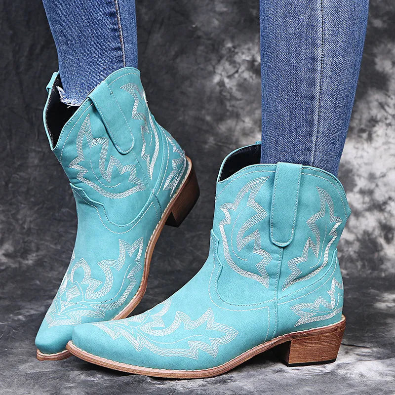 Blue women's cowboy boots with white embroidery, a low wedge heel, and a pointed toe