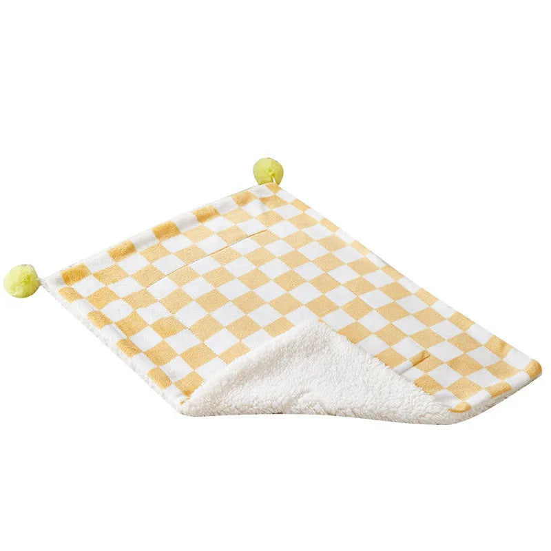 Plush cotton fleece pet blanket with plaid pattern and fur balls in green colour on couch