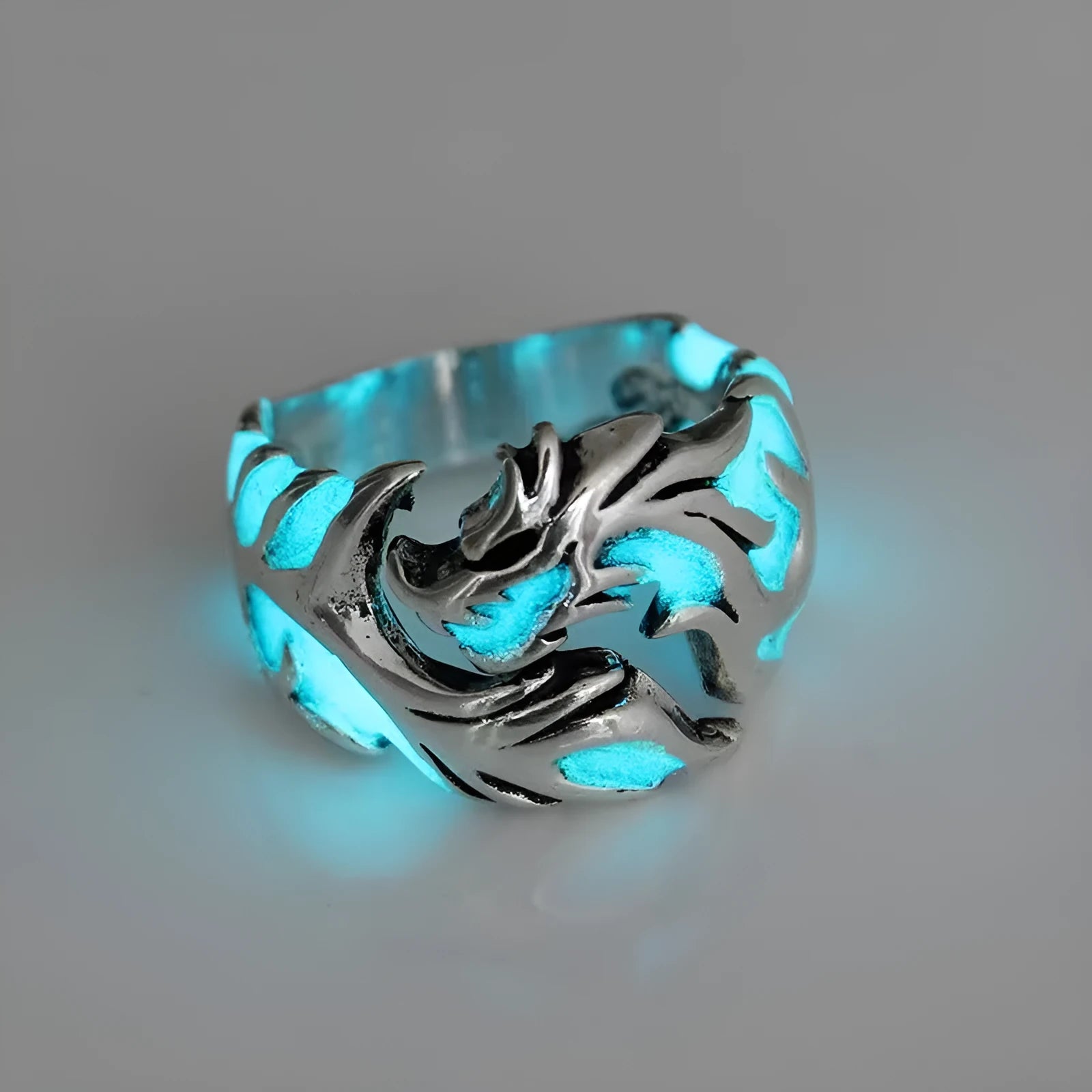 Close-up of an adjustable silver blue and green metal ring with a Chinese dragon pattern.