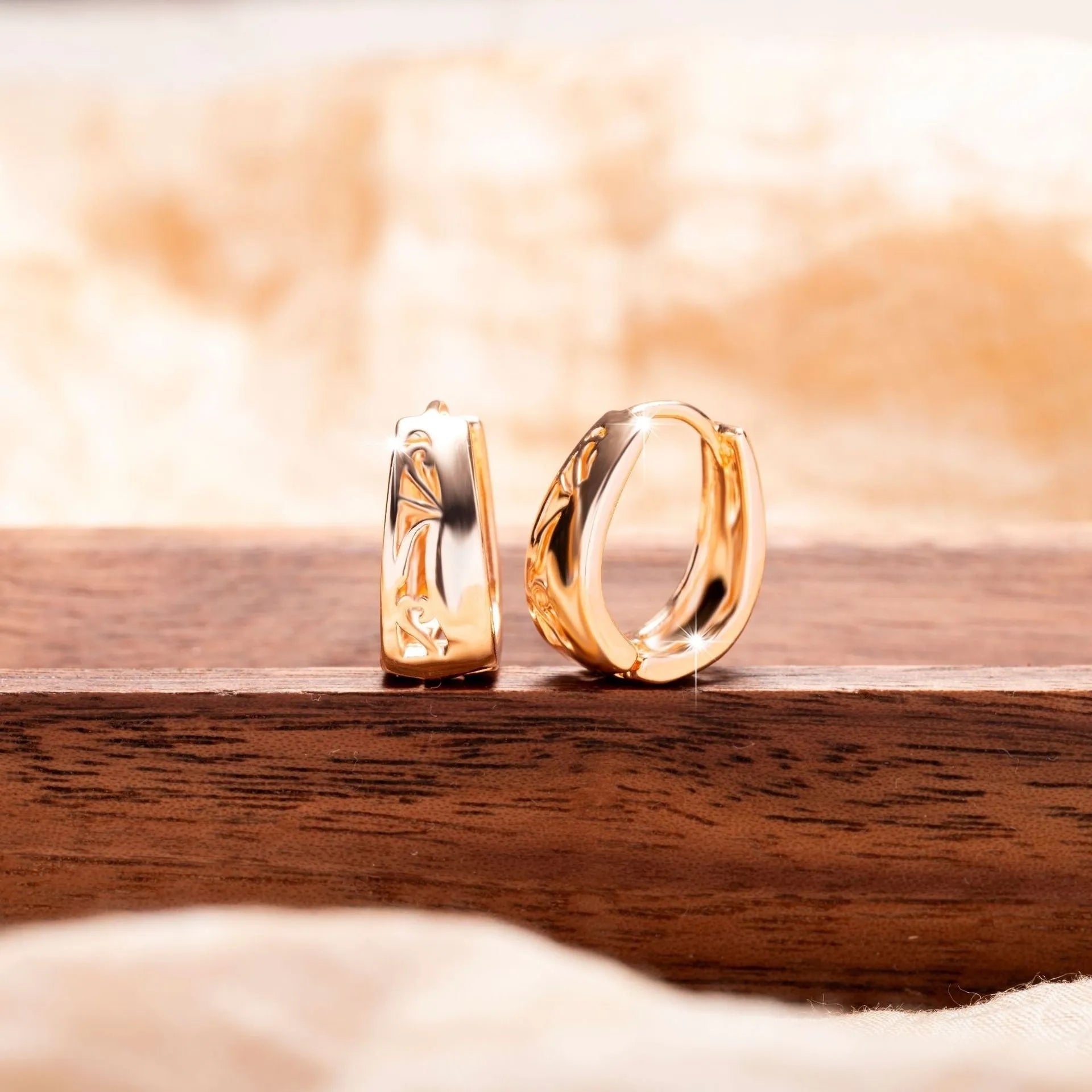 Rose gold hollow carved U-shaped copper earrings on light background
