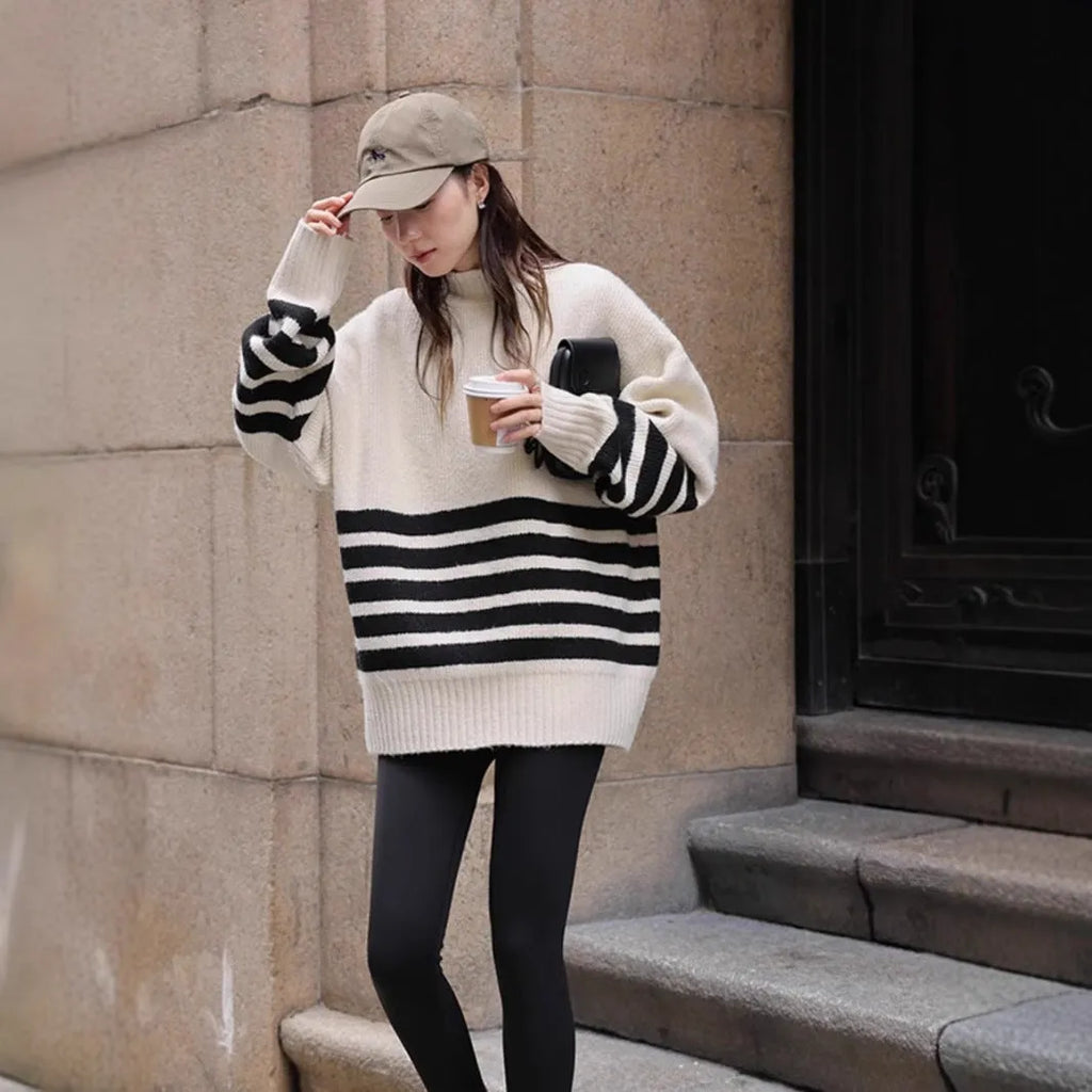 Beige winter maternity sweater with stand collar, loose fit, long sleeves, and striped plaid pattern on a woman