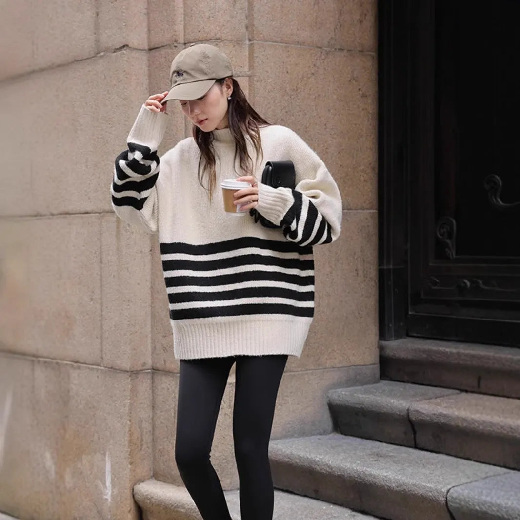 Beige winter maternity sweater with stand collar, loose fit, long sleeves, and striped plaid pattern on a woman