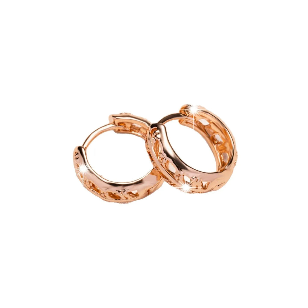 Small rose gold hollowed-out copper earrings with a leaf and a heart pendant design.