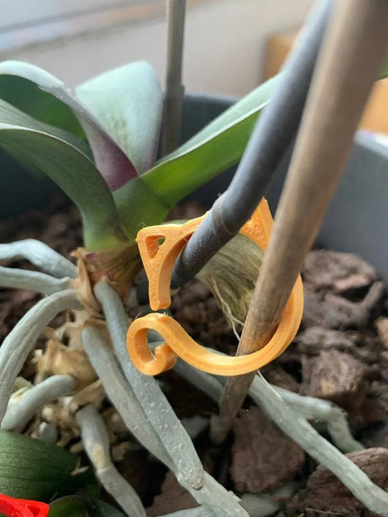 Colourful cat-shaped plastic plant clip for indoor gardening support.