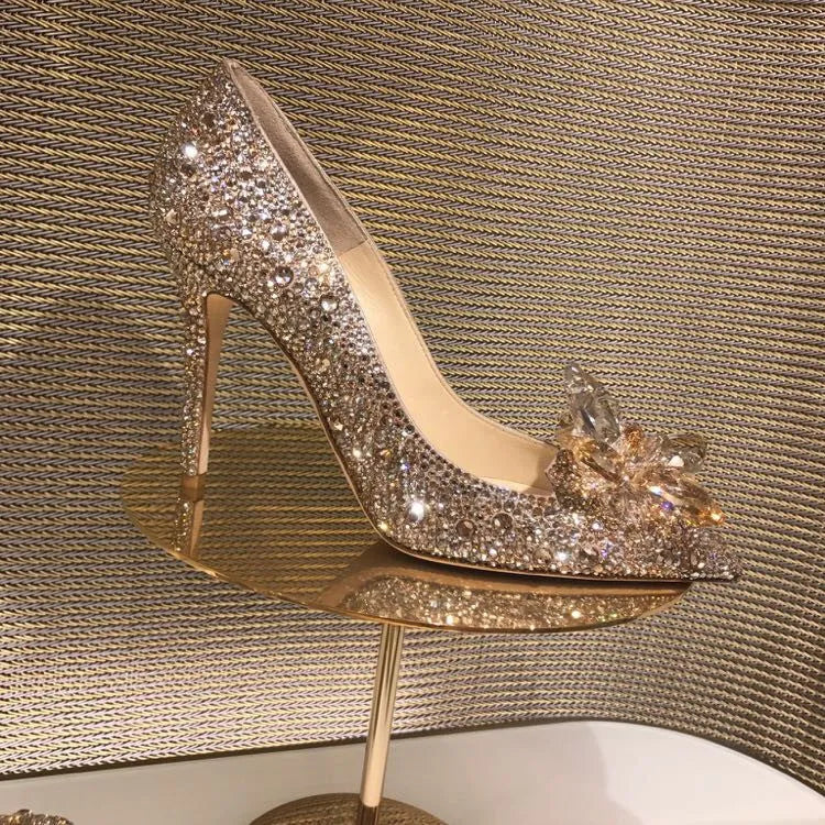 Gold women's high heel with pointed toe, rhinestones, and a stiletto heel on a white background.
