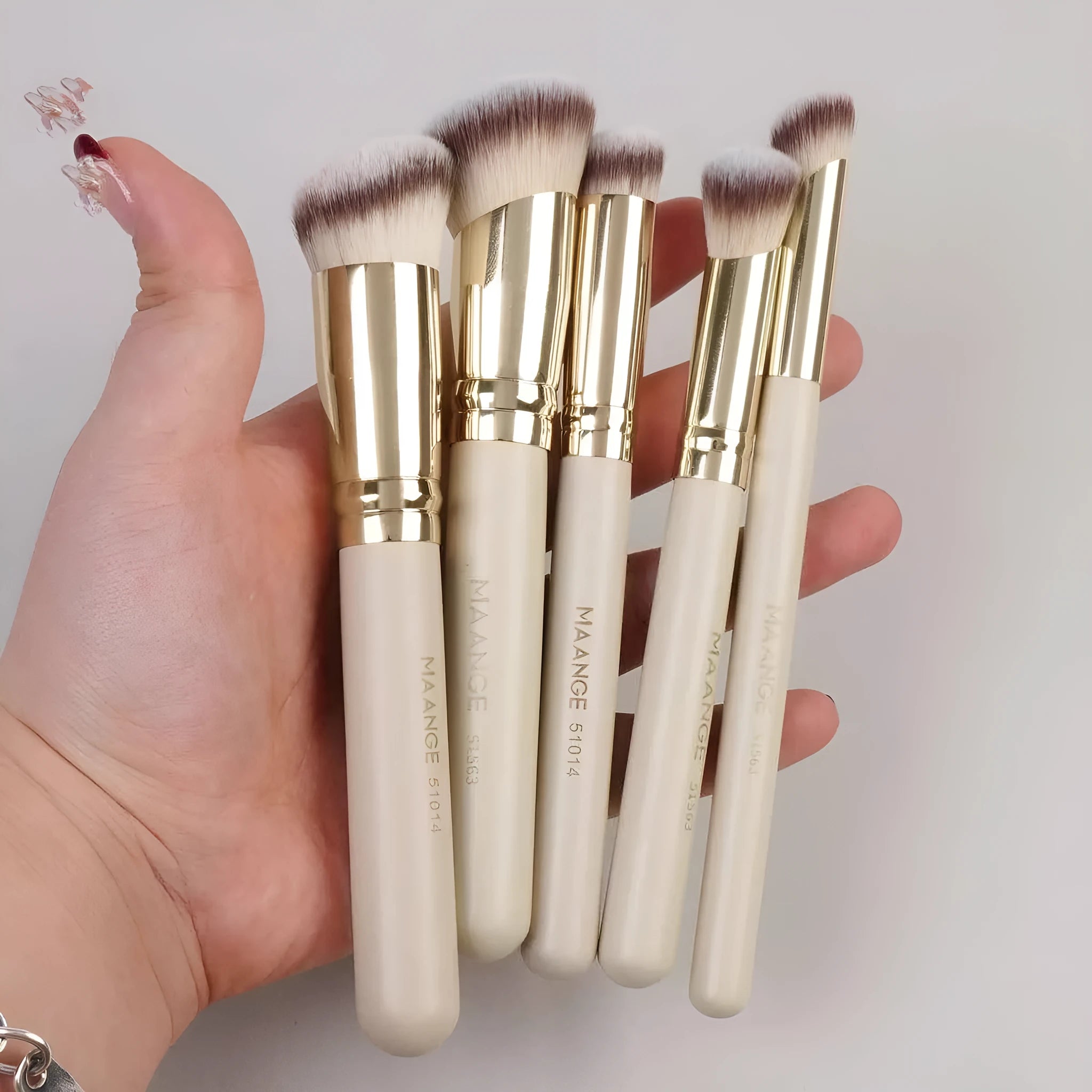 Five apricot coloured makeup brushes with synthetic bristles including angled blusher brush