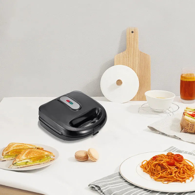 Black electric sandwich pan with double-sided heating, brushed stainless steel top, and non-stick baking surface