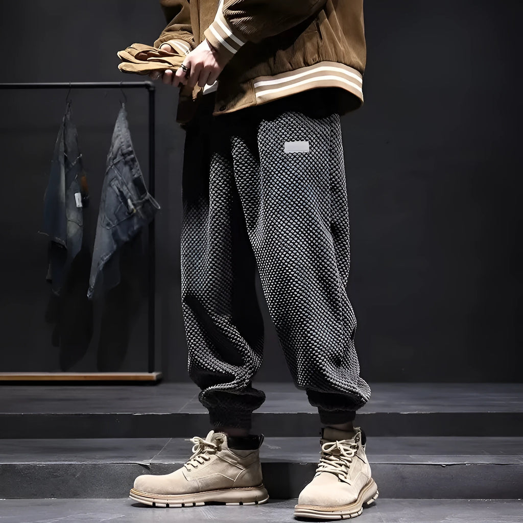 Men's grey ankle-tied straight leg sweatpants with elastic waist on a white background.