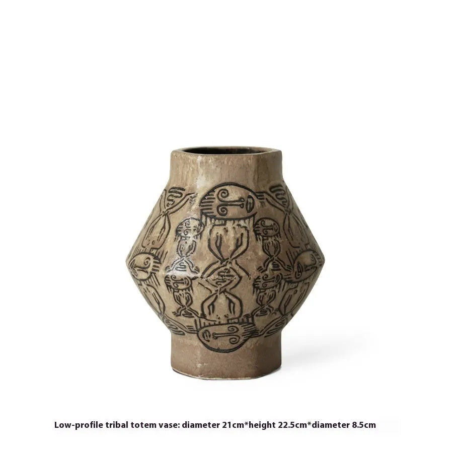 Hand-painted ceramic vase with carved tribal totem art in cylindrical shape.
