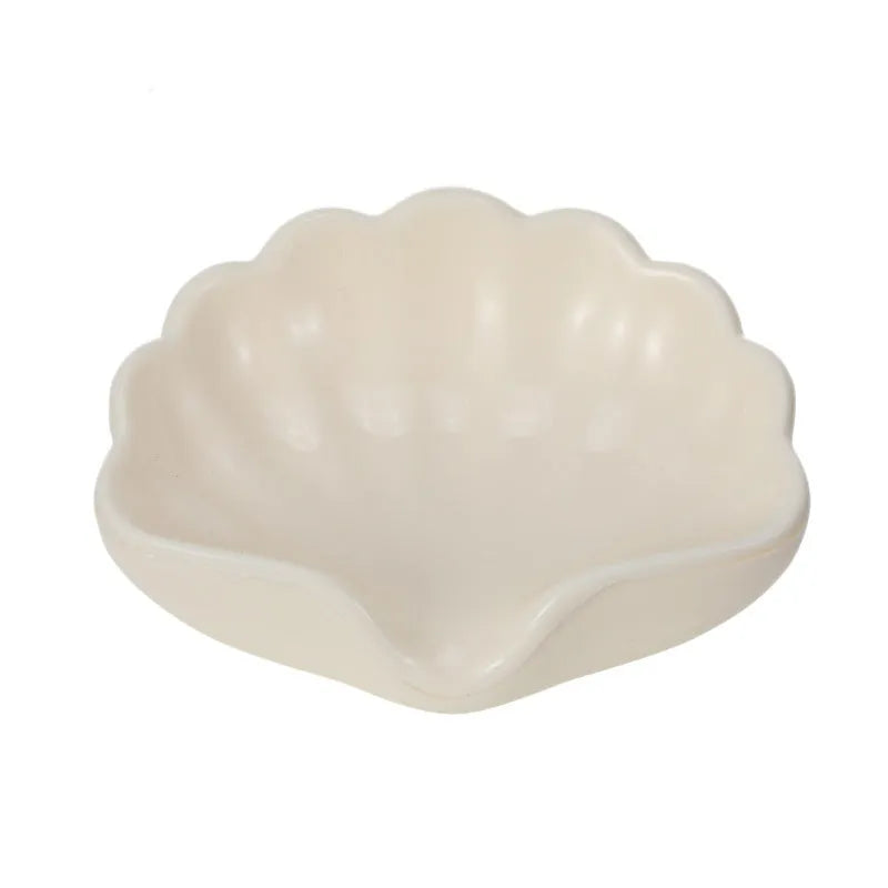 White shell-shaped plastic soap dish on a bathroom counter.
