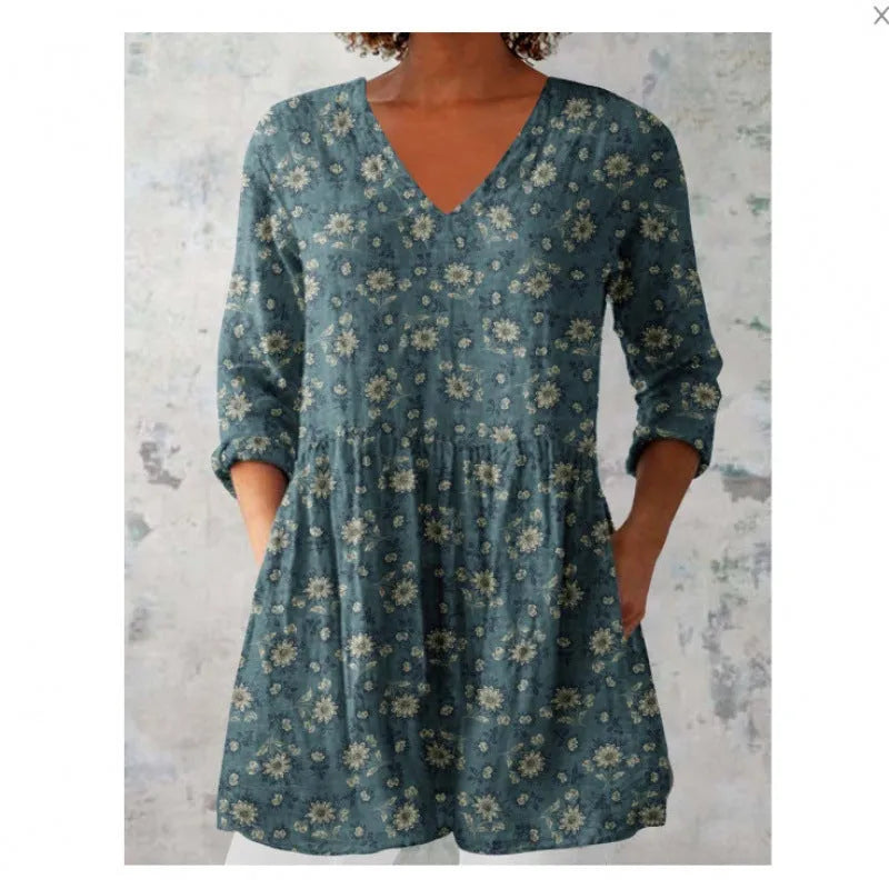 A woman modelling a printed, loose-fitting dress with a wide waist and three-quarter length sleeves.