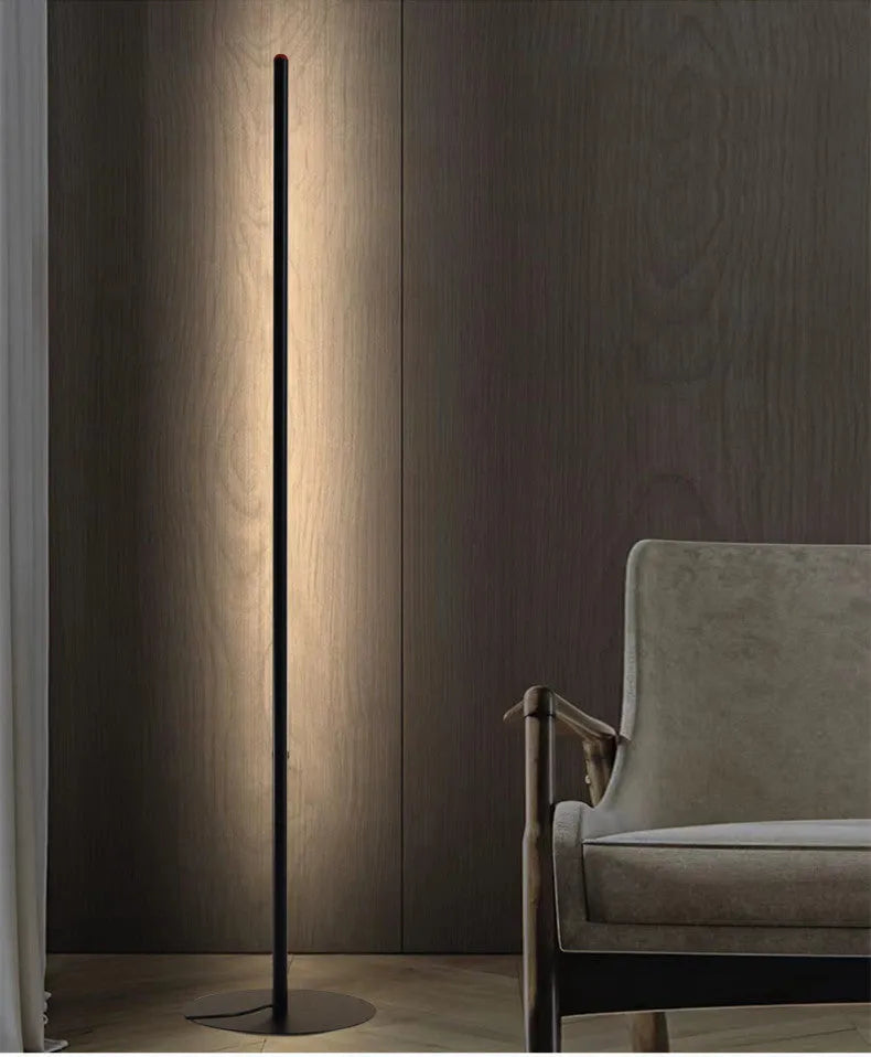 Modern simple vertical aluminium alloy floor lamp in silver, shown beside a sofa.