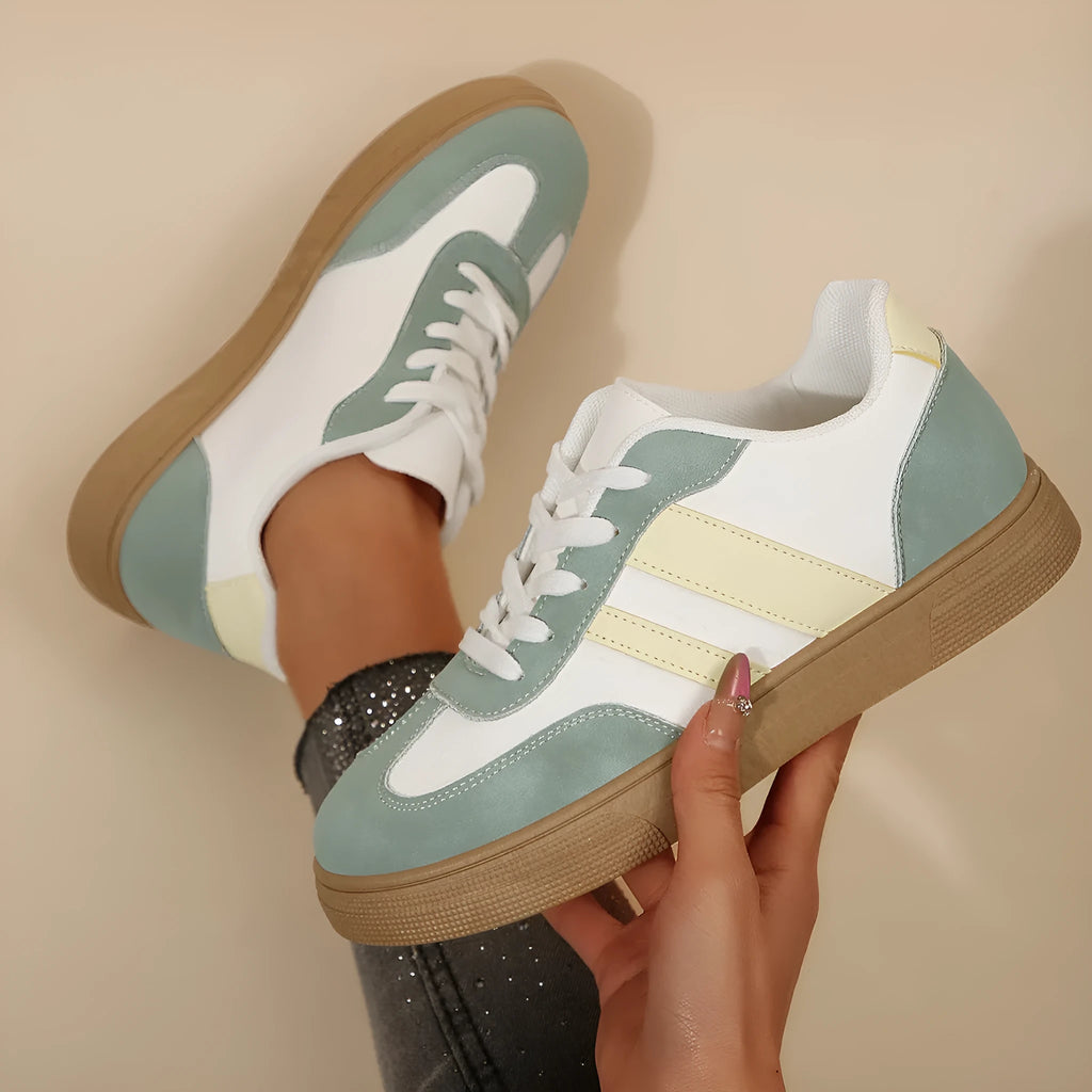 Women's retro sports shoes in white with green candy colour accents and cross-strap details on PU leather upper.