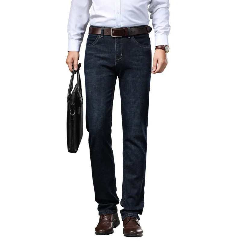 Man wearing black loose fit straight leg stretch denim jeans, showing mid waist and zip fly.