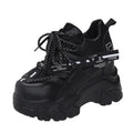 Women's white and black mesh platform tennis shoes with cross strap and thick rubber sole.