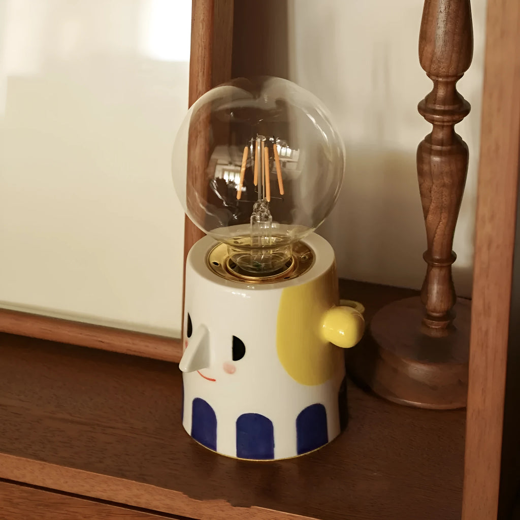 Handmade ceramic table lamp with a spherical ball headlight design on a bedside table.