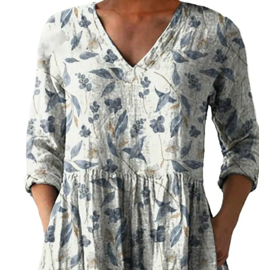 A woman modelling a printed, loose-fitting dress with a wide waist and three-quarter length sleeves.