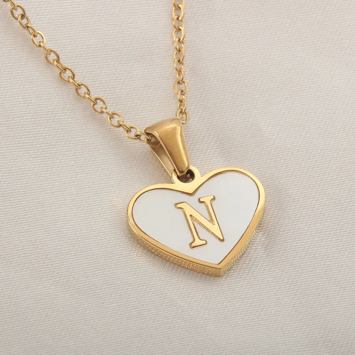 Gold heart necklace with white shell detail and personalised initial letter on adjustable chain