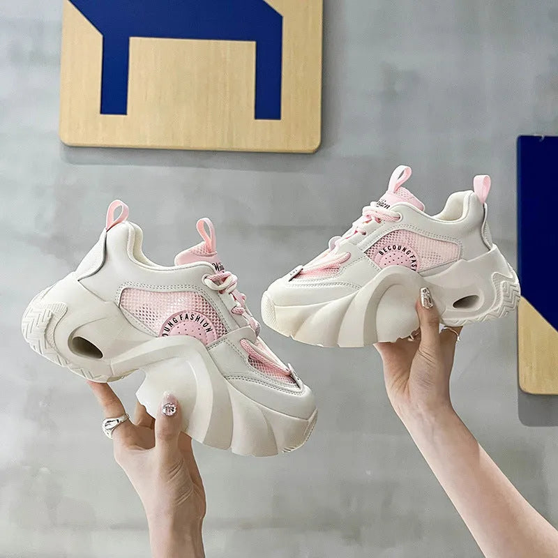Women's pink sneakers with thick sole, cross ankle straps and mesh lining.