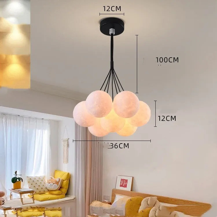 Nordic fish-shaped pendant chandelier with cluster of spherical moon bubble lights in gold or black finish.