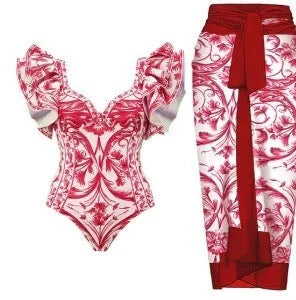 Adult woman modelling a printed one-piece swimsuit in a choice of colours including rose pink, blue, white, and a red apron set style.