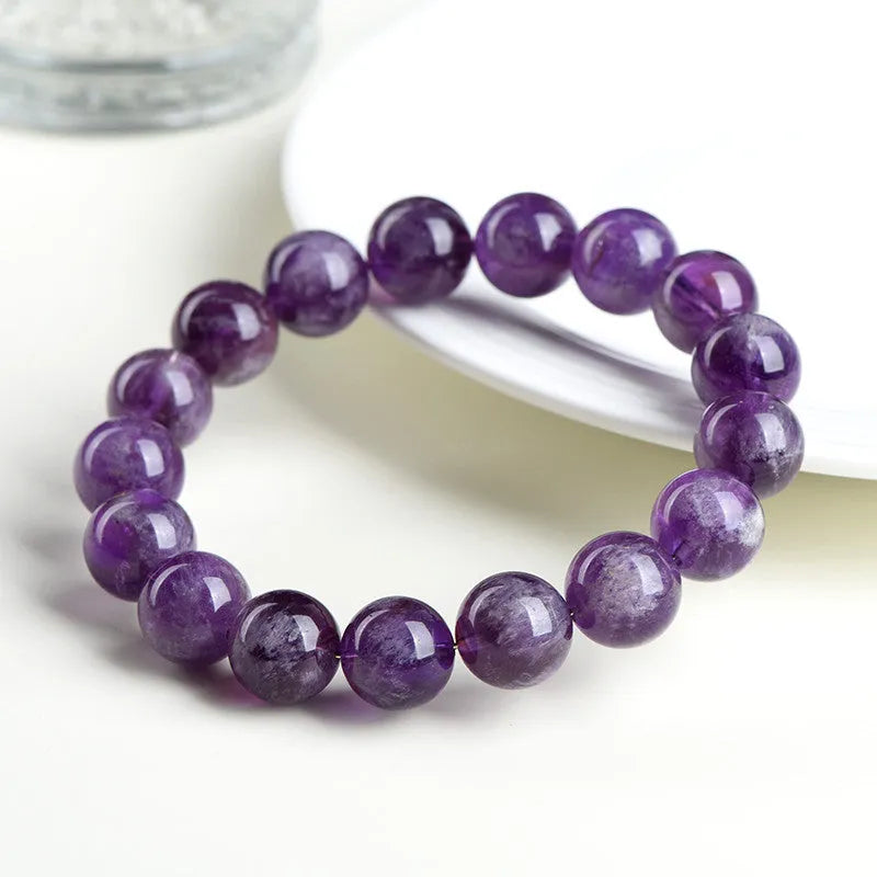 Natural Snow Mountain Purple Feather Amethyst crystal bracelet with scattered geometric beads featuring a Ruyi pattern.