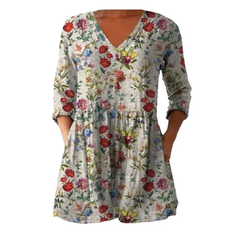 A woman modelling a printed, loose-fitting dress with a wide waist and three-quarter length sleeves.