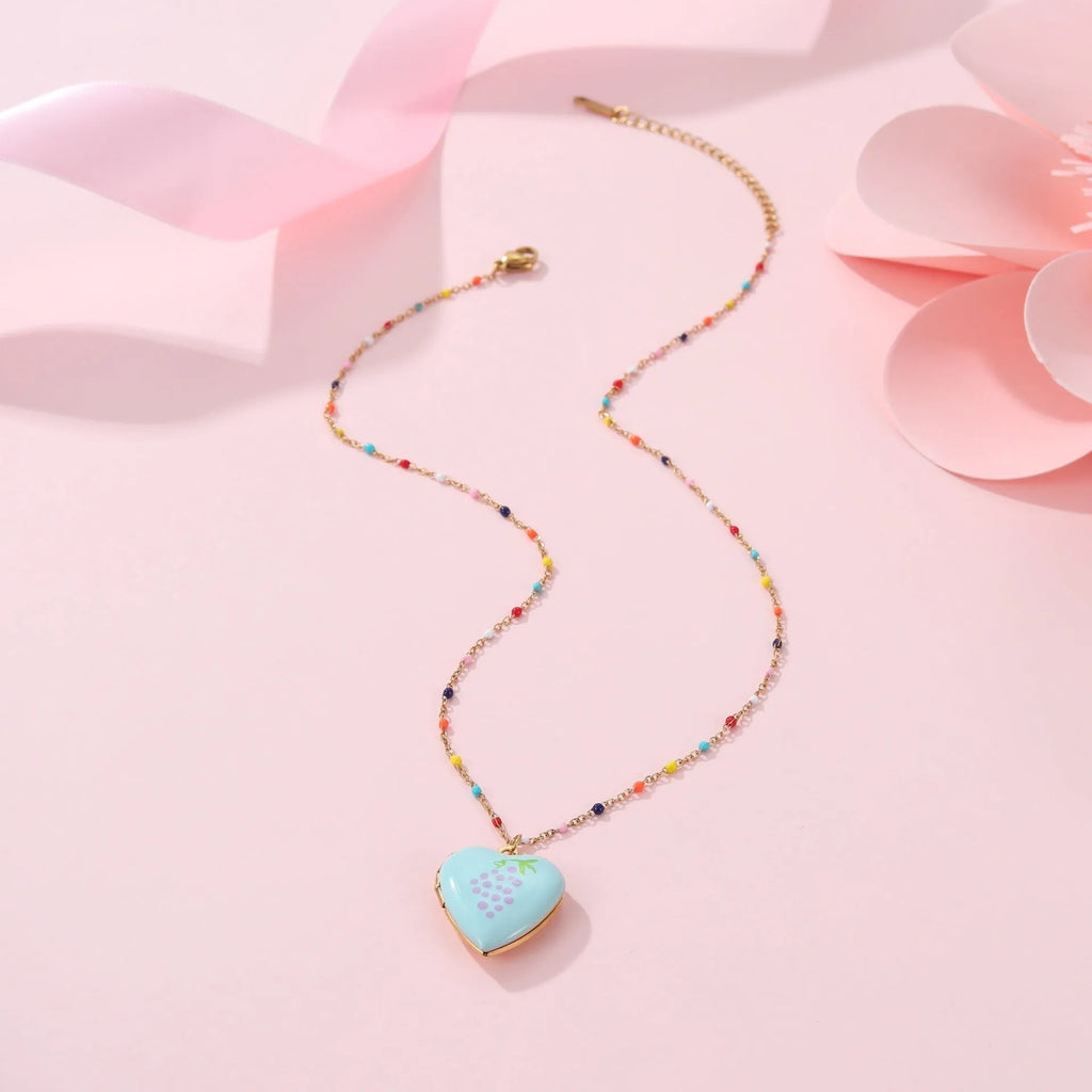 Gold-plated heart-shaped fruit pendant necklace on a stainless steel chain, showing grape design detail.