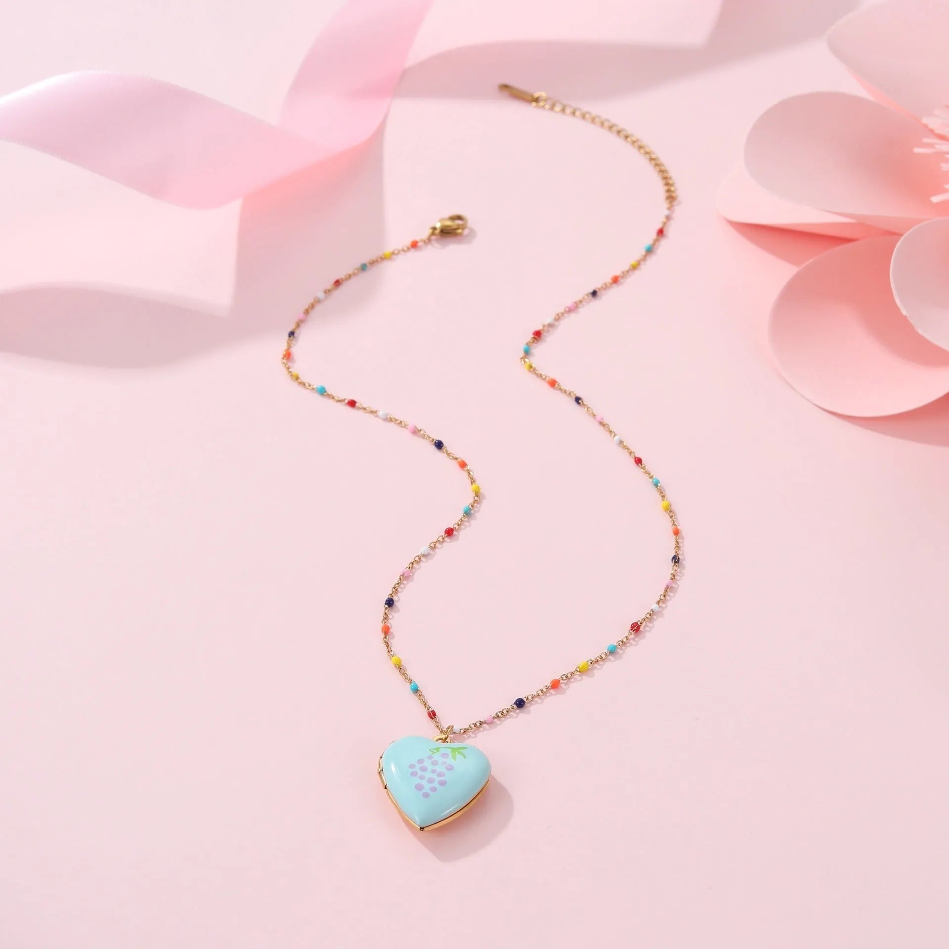 Gold-plated heart-shaped fruit pendant necklace on a stainless steel chain, showing grape design detail.