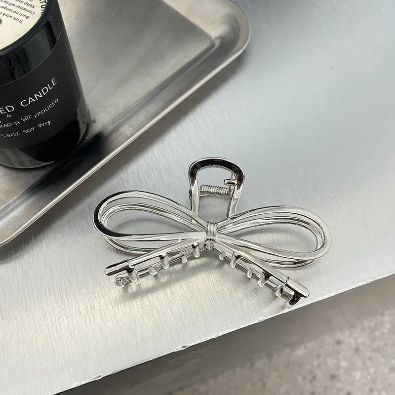A silver women's hair barrette with a decorative Korean-style bow and an alloy clip.