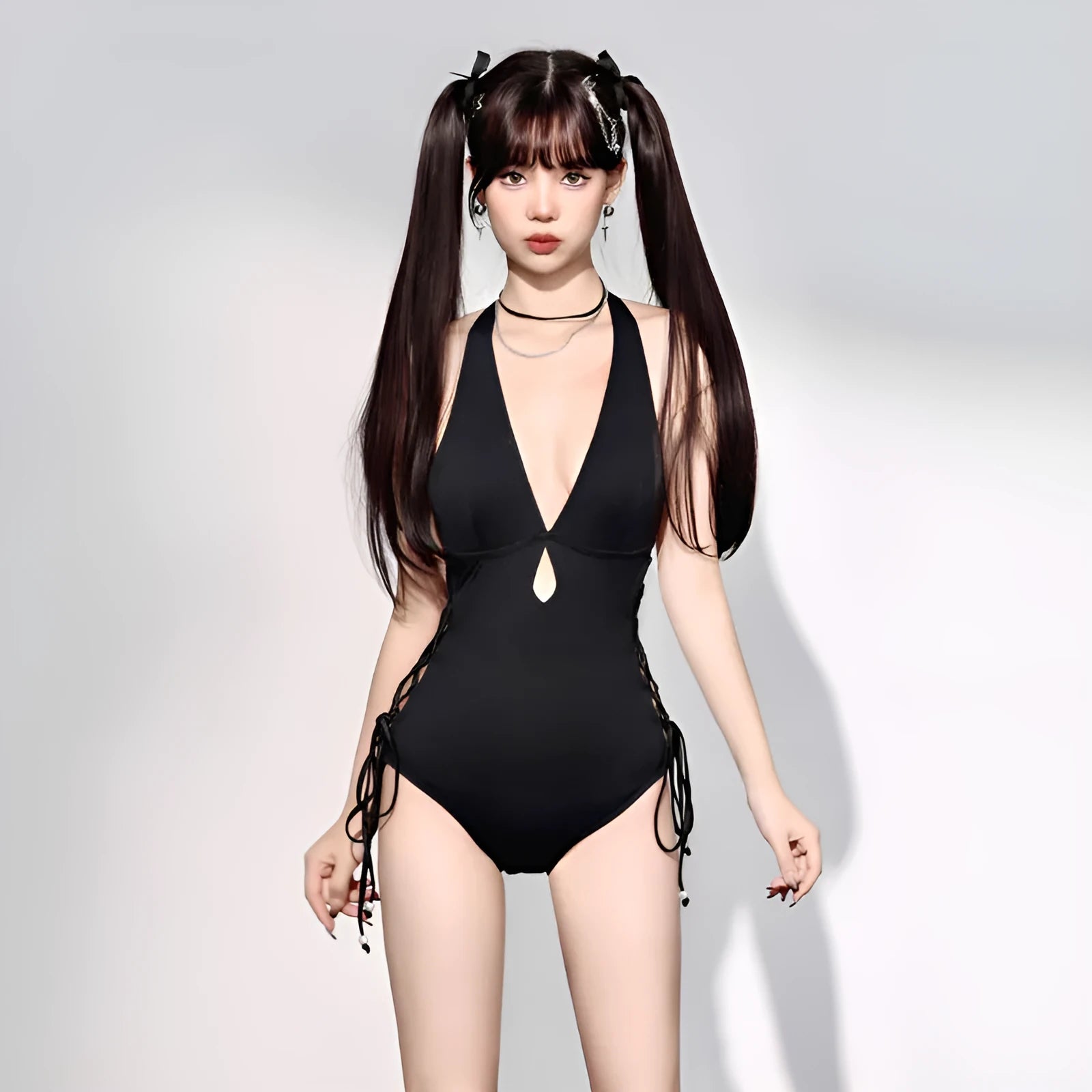 Women's V-neck hollow strap one-piece swimsuit in black, front view, shown on a model